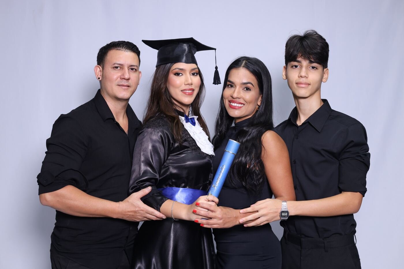 Família de preto ao redor da formanda de beca