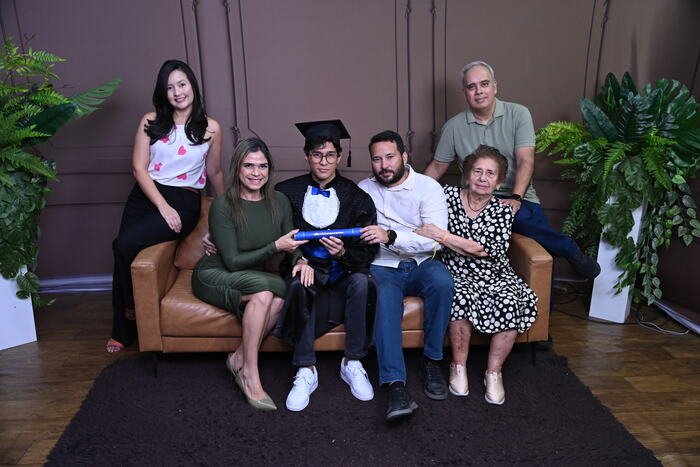 Família no sofá com o formando de beca