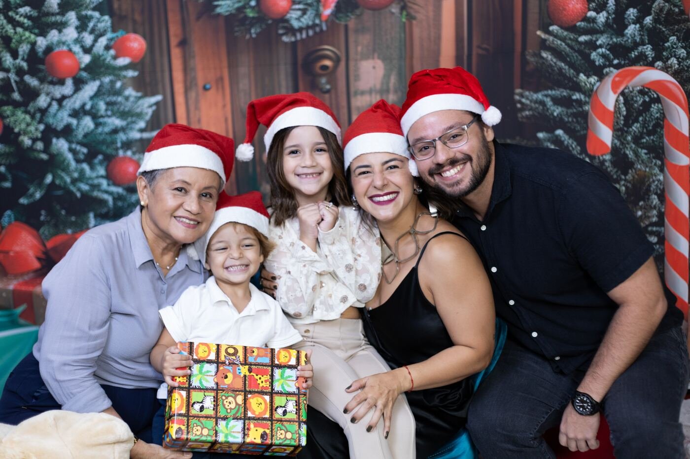 Família com gorros de Papai Noel no cenário de Natal