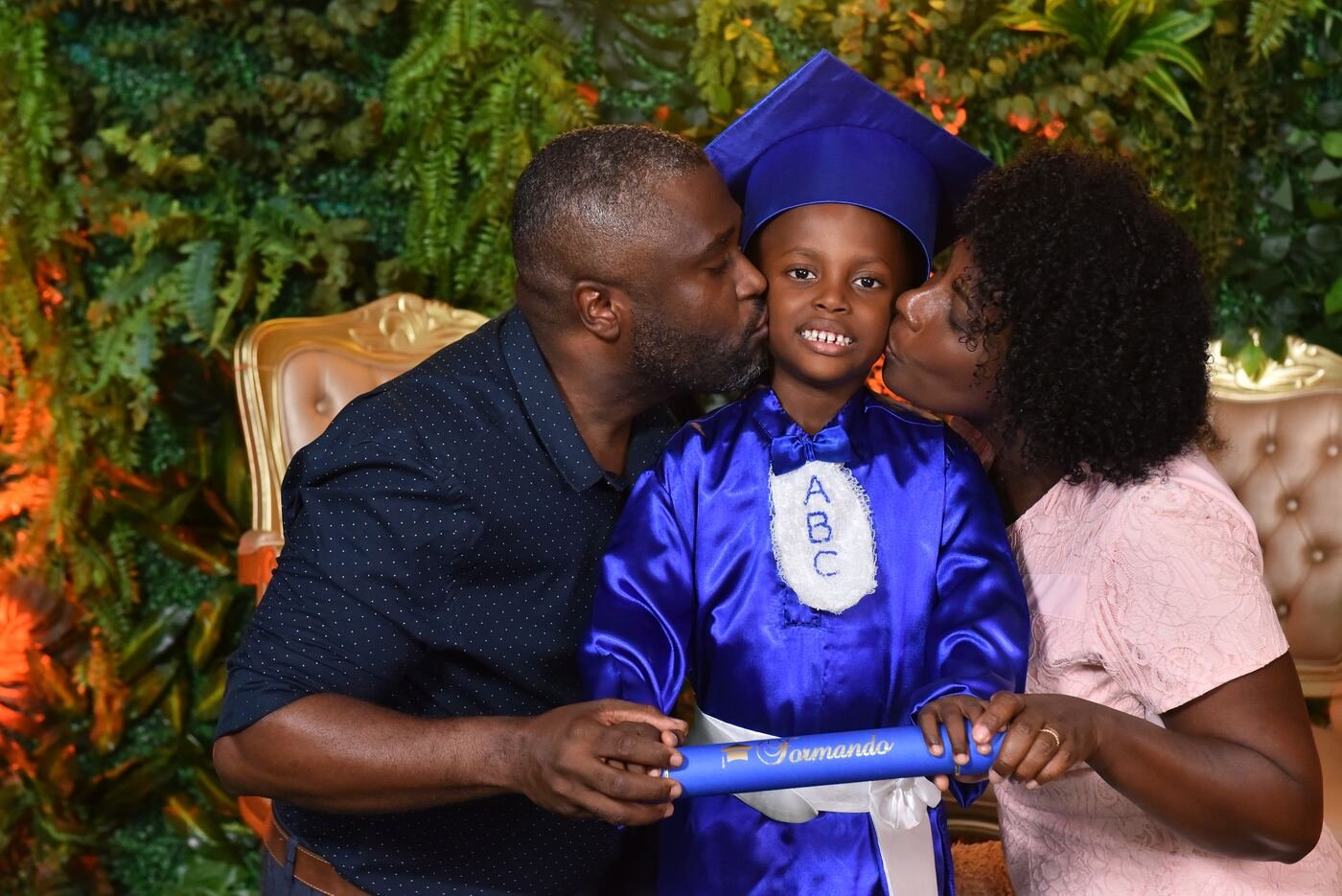 Pais beijando o filho de beca azul